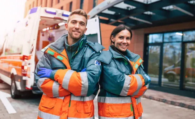 急救医疗技术员s Smiling Standing Besides Ambulance